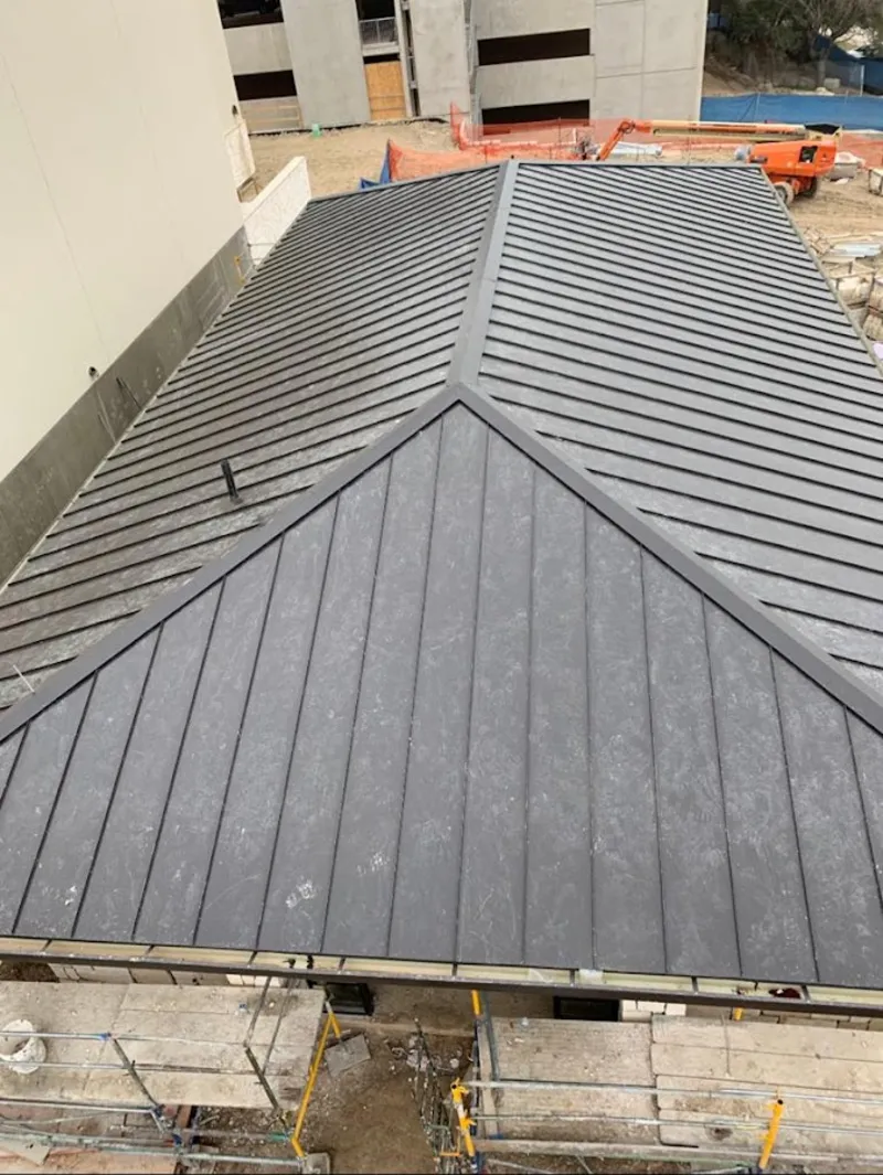 Commercial metal roof construction with crane equipment in Conover